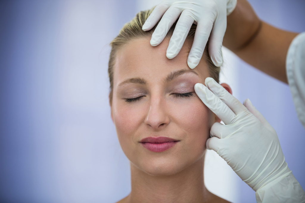 doctor-examining-female-patients-face-from-cosmetic-treatment.jpg